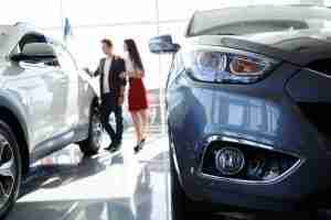 young couple in car dealership
