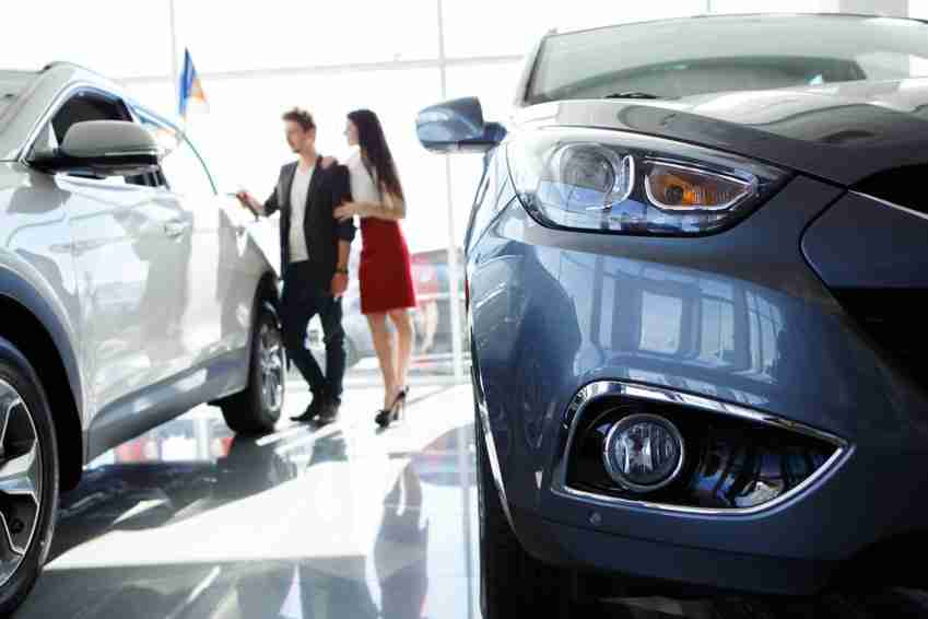 young couple in car dealership