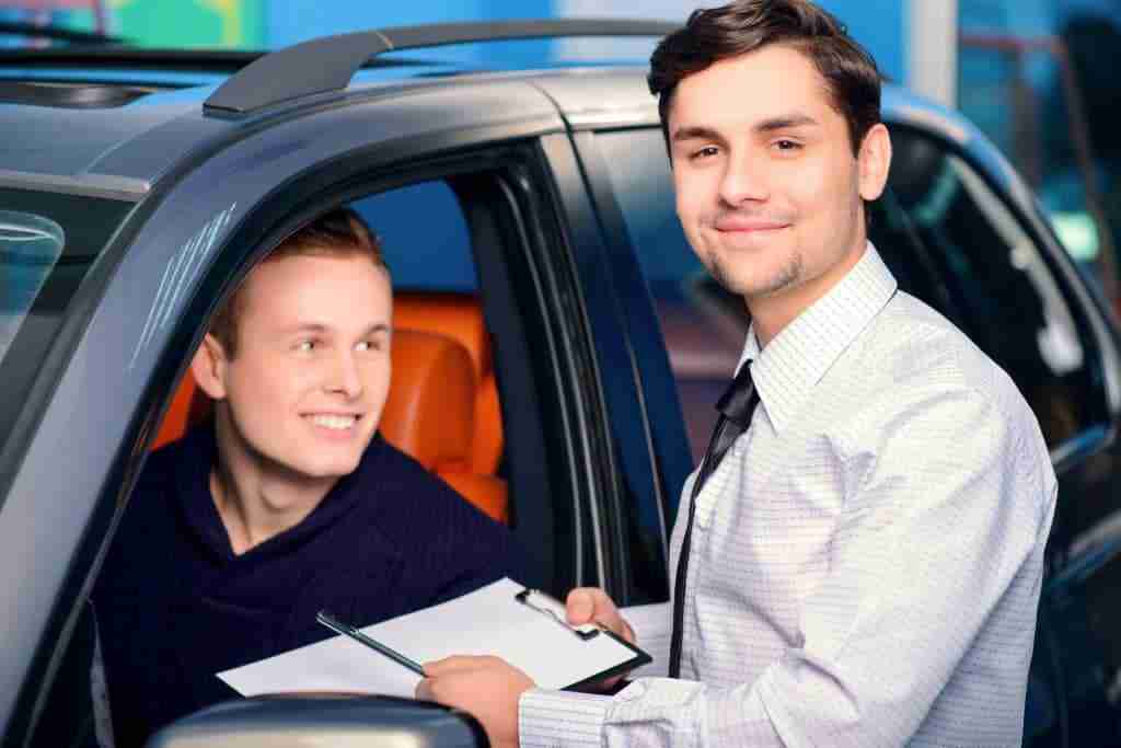 Car salesmen with young car buyer