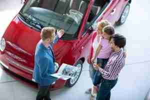 Car Salesmen Showing Family Red Car