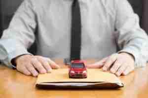Toy car on top of car salesmen envelope.