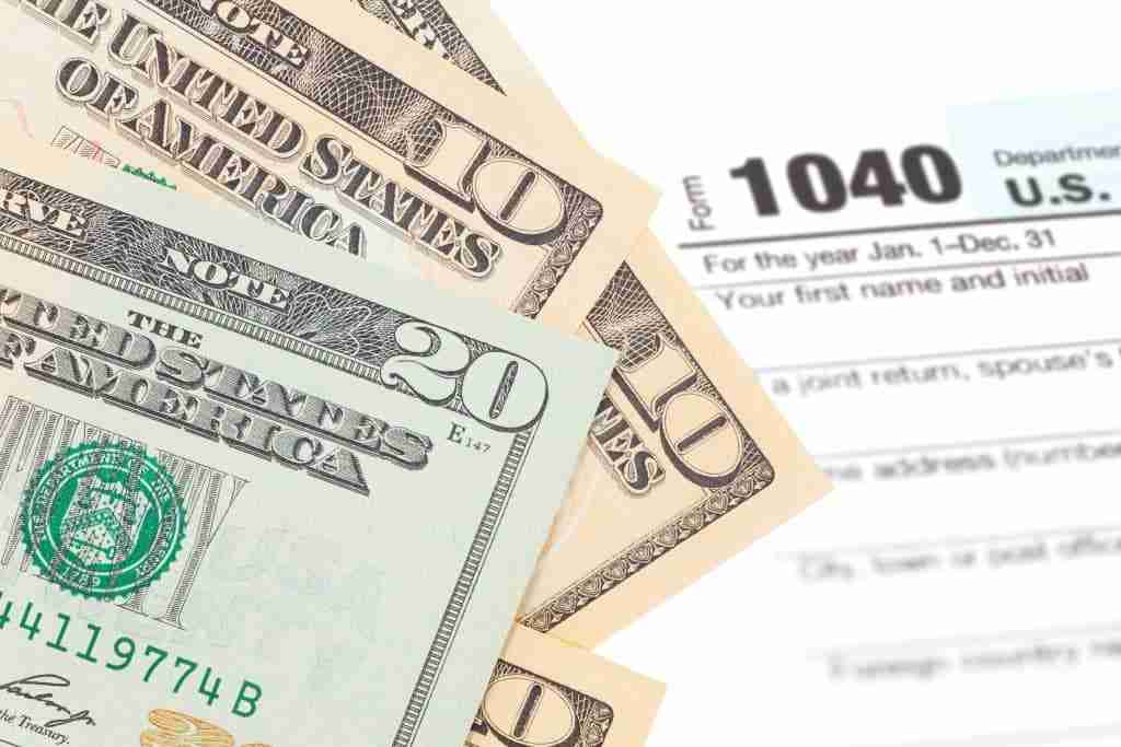 Turning Tax Refunds into Down Payments 24 Money laid over the top of a tax refund form