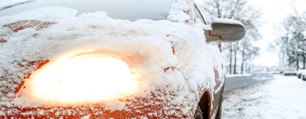 Don't Let the Winter Months Freeze Out Your Sales 13 Red car frozen over in the snow with lights on.